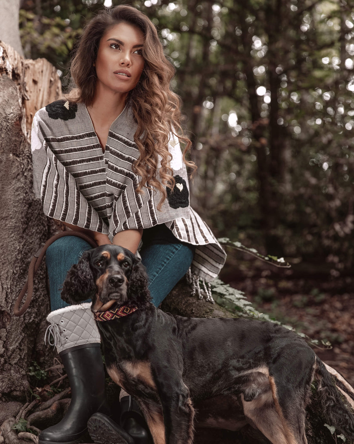 Woman relaxing in the forest and walking her dog wearing Táabal Flowers Poncho by 32 Estados