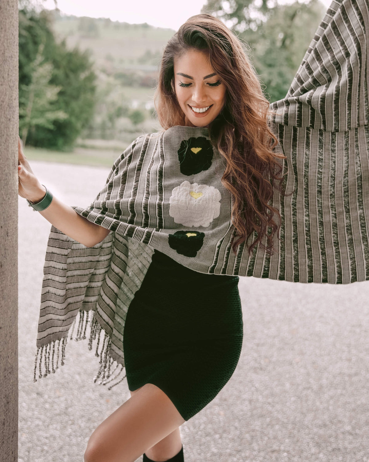 Happy woman being herself wearing Táabal flowers poncho by 32 Estados