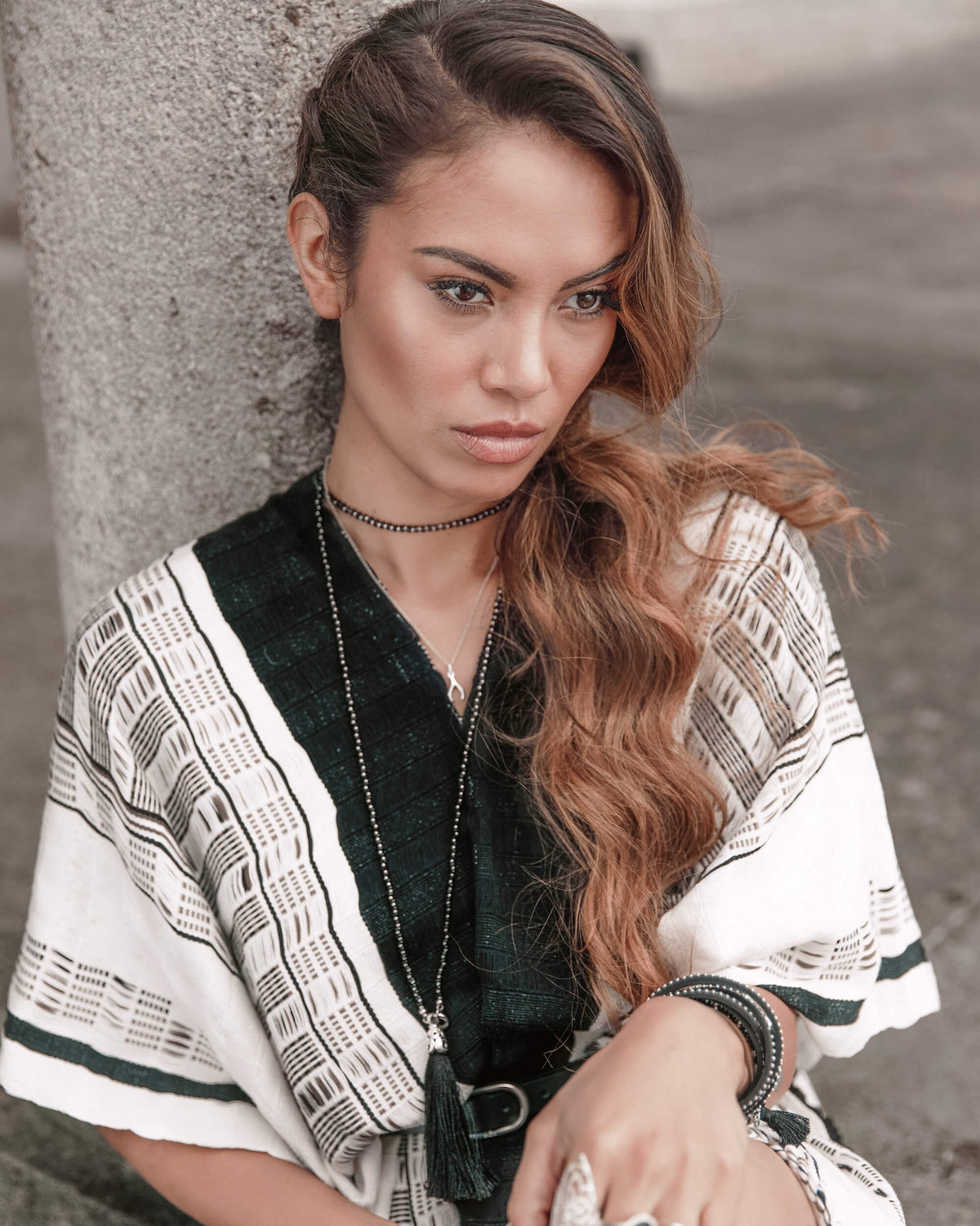 Relaxed and stylish woman thinking ahead wearing Táabal Black & White Poncho by 32 Estados