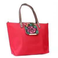 Side view of camelia red bag with handmade flower embroidery