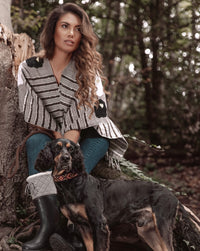 Woman relaxing in the forest and walking her dog wearing Táabal Flowers Poncho by 32 Estados