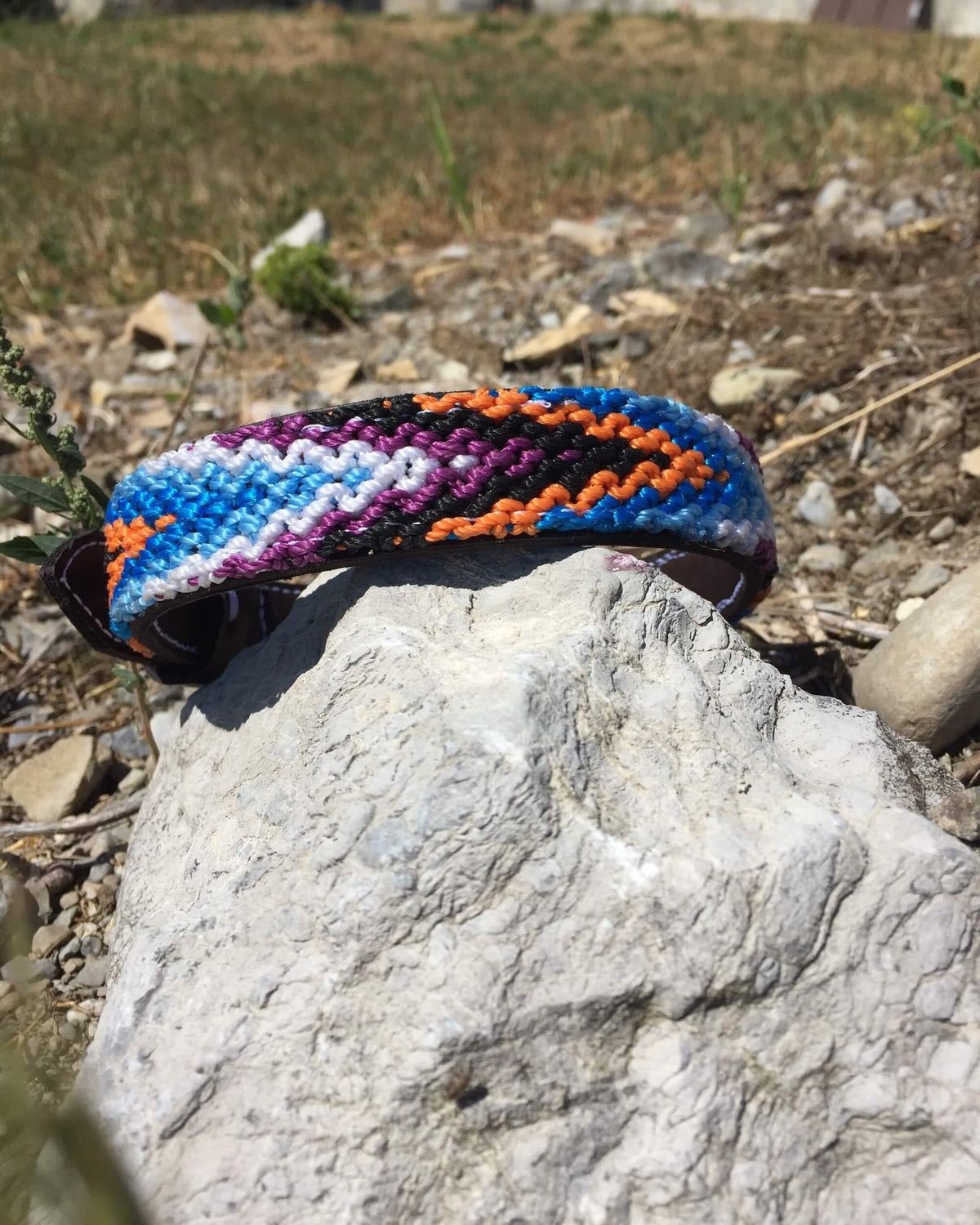 Makan Medium Size Dog Collar Blue, Orange & Purple on top of rock