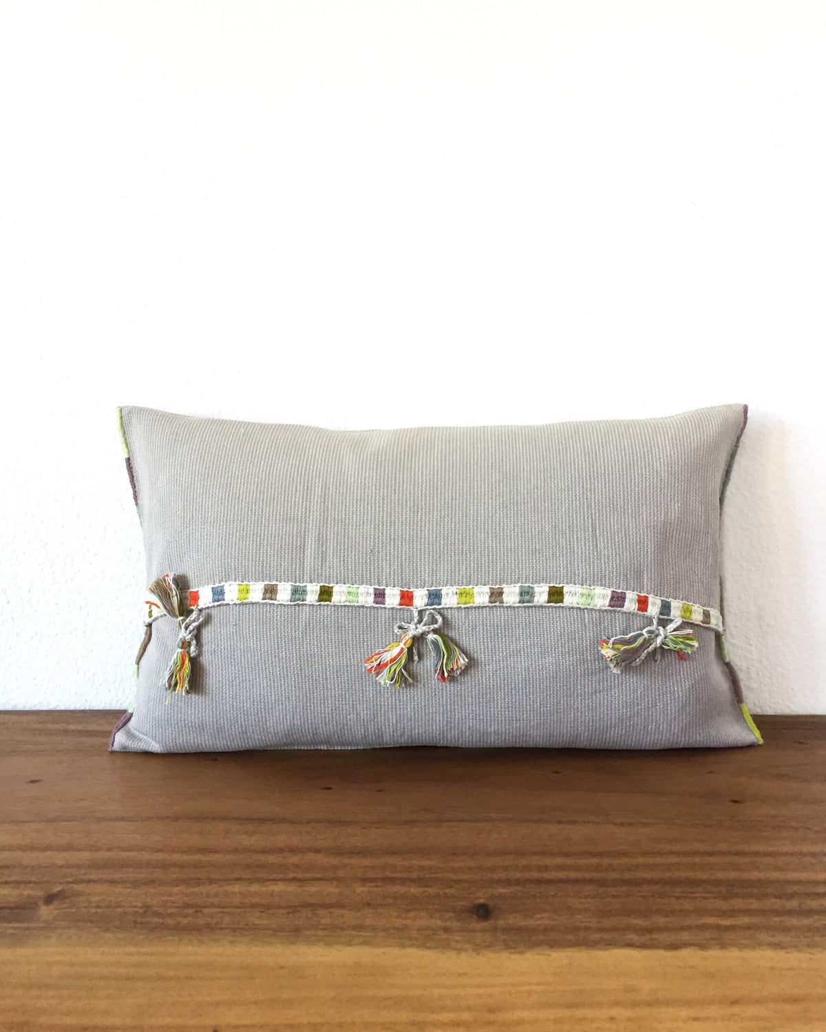 Universo Luna Throw Pillow light grey with brocades in pastel colors back view with ribbons